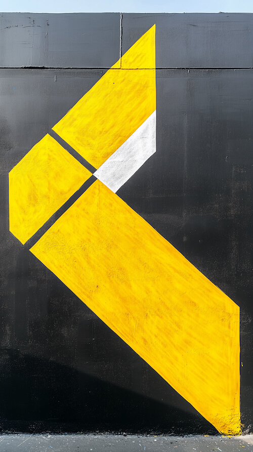 yellow-and-white-arrow-painted-on-the-side-of-an-industrial-building